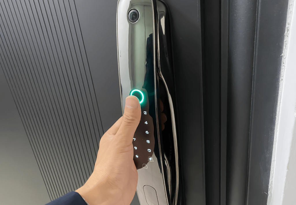 Hand betätigt einen smarten Türgriff mit Fingerabdrucksensor und Zahlentastatur