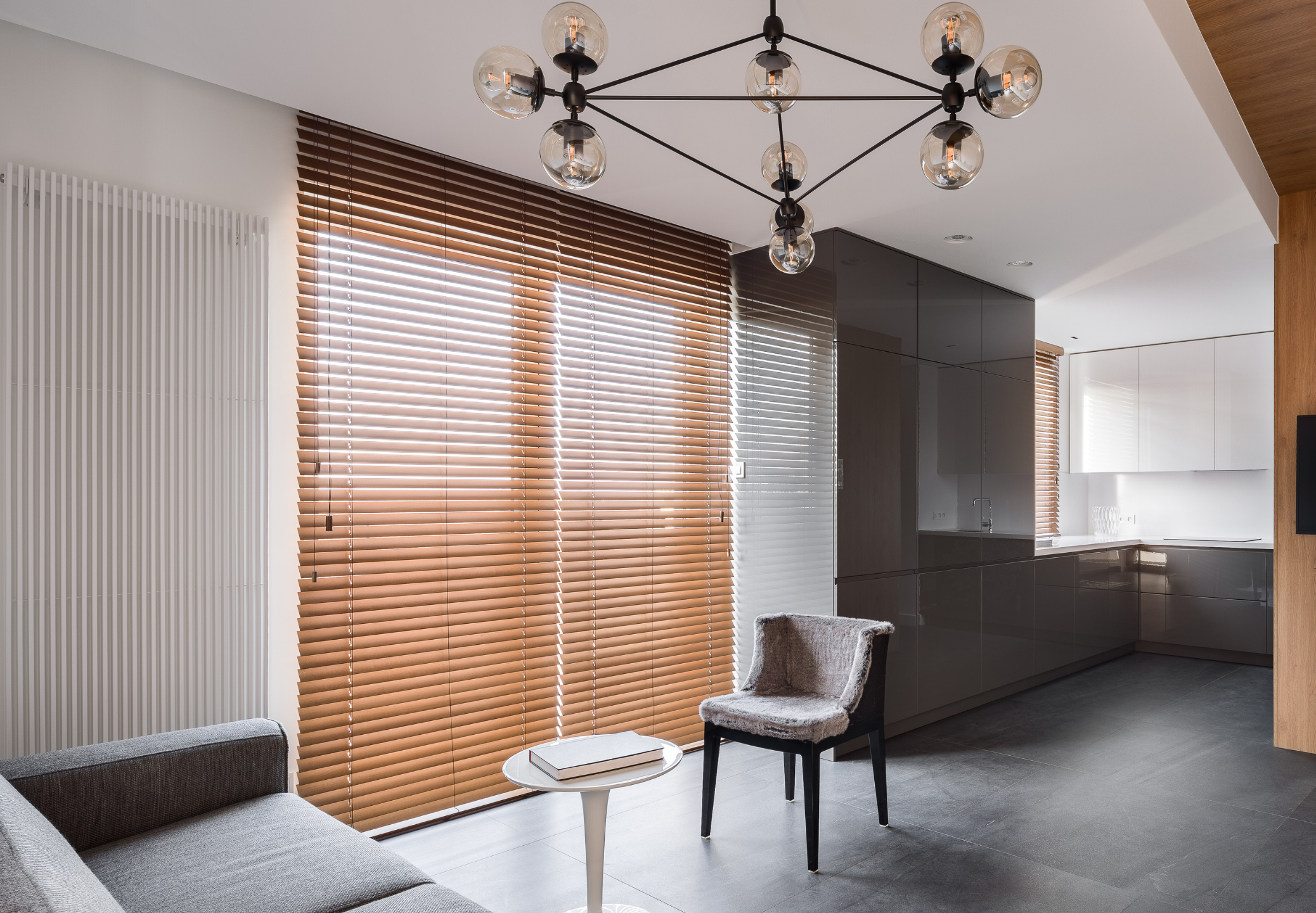 Modernes Wohnzimmer mit großen Holzjalousien vor einer Fensterfront